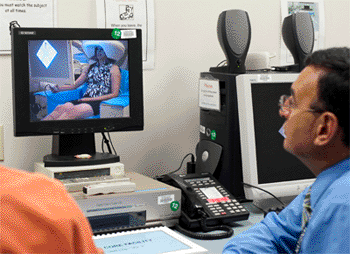 Image: Dr. Zarate views subject in MEG scanner from scanner control room (Photo courtesy of the NIMH).